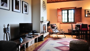 A living room with a fireplace, a television, and framed pictures on the wall. - Villa Ava - Four Bedroom Villa, Sleeps 8 (Refóios do Lima)