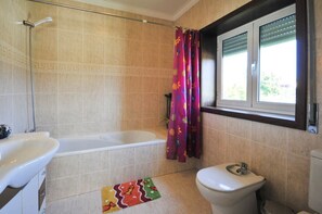 Ein Badezimmer mit Badewanne, Toilette und Waschbecken.