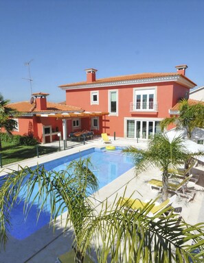 A two-story building with a swimming pool, outdoor seating, and a clear sky. - Moradia Marinhas - Five Bedroom Villa, Sleeps 10 (Fão)