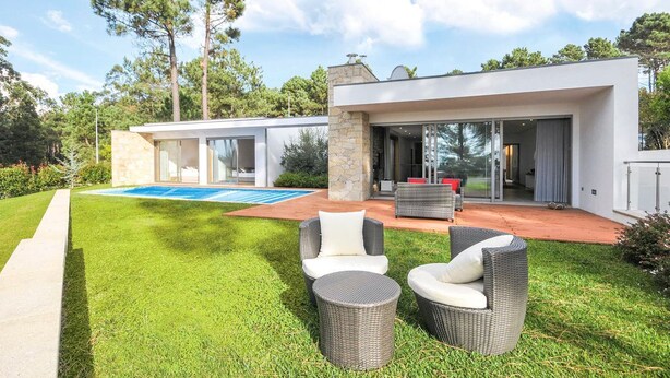 A modern house with a swimming pool, outdoor seating, and a stone pillar. - Villa Senande - Five Bedroom Villa, Sleeps 10 (Âncora)