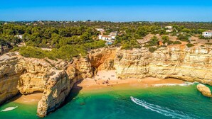 A coastal area with cliffs, a beach, and several buildings. - Quinta Jordia - Twelve Bedroom Villa, Sleeps 26 (Lagoa)
