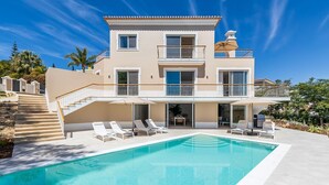 A two-story building with a swimming pool, outdoor seating, and a staircase leading to the upper level. - Villa Catao - Four Bedroom Villa, Sleeps 8 (Almansil)