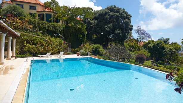 A rectangular swimming pool with a clear blue water surface, surrounded by a tiled deck. - Villa Quinta Santa Luzia (Funchal)