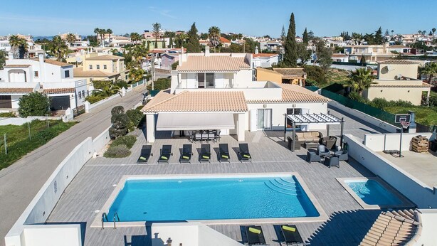 Il s’agit d’une propriété résidentielle dotée d’une piscine, de chaises longues et d’un patio couvert.