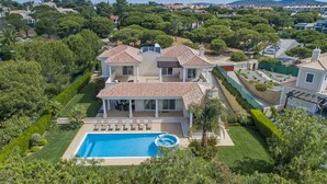 A large villa with a swimming pool, multiple terraces, and lush gardens.