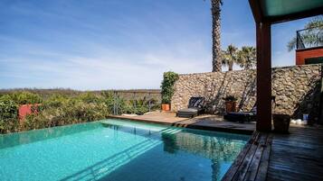 An infinity pool, a heated pool, sun loungers