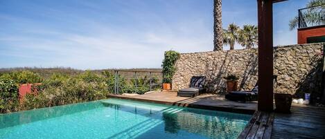 Piscine à débordement, piscine chauffée, chaises longues