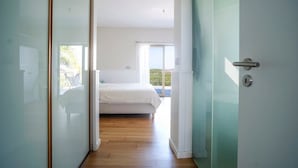 Un dormitorio con cama, vistas al exterior y una puerta con manija.