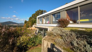 A modern house with large glass windows, a flat roof, and a view of a mountainous landscape. - Villa Esqueiro - Three Bedroom Villa, Sleeps 6 (Moledo)
