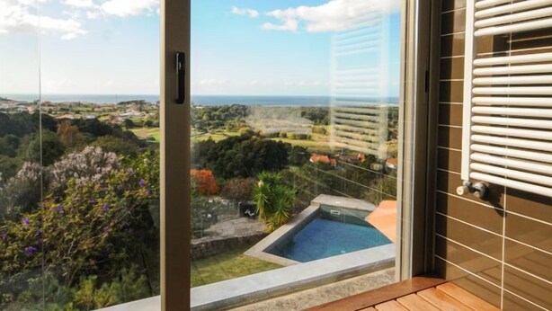 A balcony with a wooden floor and a glass door leading to a pool. - Villa Esqueiro - Three Bedroom Villa, Sleeps 6 (Moledo)