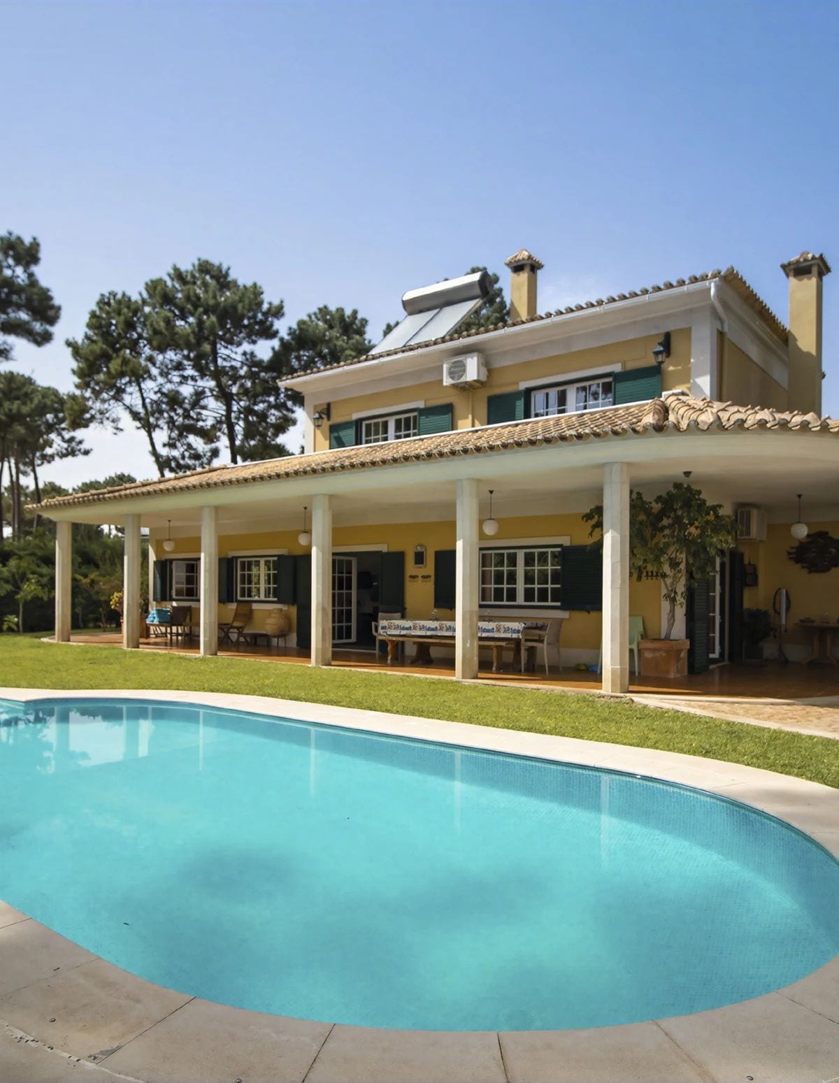 A two-story house with a swimming pool in front.