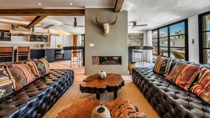 A spacious living area with leather sofas, a central coffee table, and a stone fireplace. - Villa Adaline - Five Bedroom Villa, Sleeps 10 (Alcaucín)