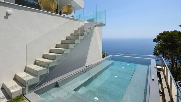 A modern building with a glass staircase leading to a rooftop infinity pool overlooking the sea. - Villa Falguerines - Six Bedroom Villa, Sleeps 12 (Begur)