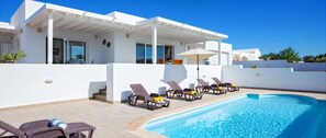 Ein moderner Poolbereich mit Liegestühlen und einem klaren, blauen Pool.