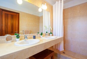 Un baño con dos lavamanos, un espejo y una cortina de ducha.