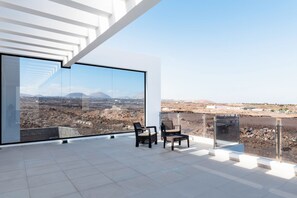 Un intérieur moderne doté d’une grande baie vitrée offrant une vue panoramique sur un paysage désertique.