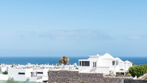 A coastal view of white buildings with a stone wall in the foreground and the sea in the background. - Villa Bernialiss - Three Bedroom Villa, Sleeps 6 (Puerto del Carmen)