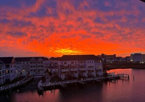 A waterfront hotel with multiple buildings, a dock, and a calm body of water reflecting the sunset. - Sunset Island 2 Hidden Cove Way, Unit 4A (Ocean City)