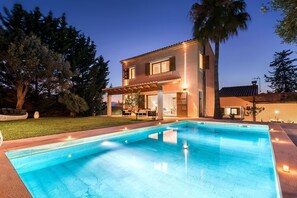Una casa de dos pisos con una piscina al frente.