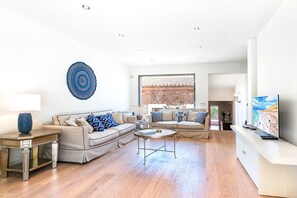 Ein modernes Wohnzimmer mit einer Couch, einem Couchtisch und einem Fernseher.