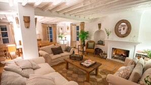 A cozy living room with a fireplace, comfortable sofas, and a coffee table. - El Cortijo - Seven Bedroom Villa, Sleeps 12 (Ronda)