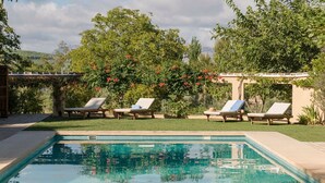A swimming pool with lounge chairs and a pergola with climbing plants. - El Cortijo - Seven Bedroom Villa, Sleeps 12 (Ronda)