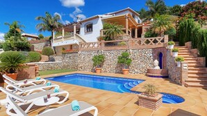 A poolside area with lounge chairs, a stone wall, and a small pool. - Villa Loli - Three Bedroom Villa, Sleeps 6 (Frigiliana)