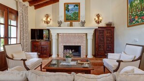 A living room with a fireplace, two armchairs, a sofa, a coffee table, and a television. - Villa Loli - Three Bedroom Villa, Sleeps 6 (Frigiliana)