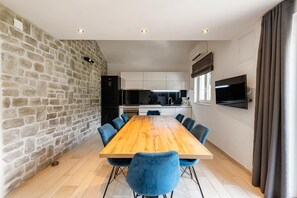 Una cocina moderna con armarios blancos, un refrigerador negro y un horno empotrado.
