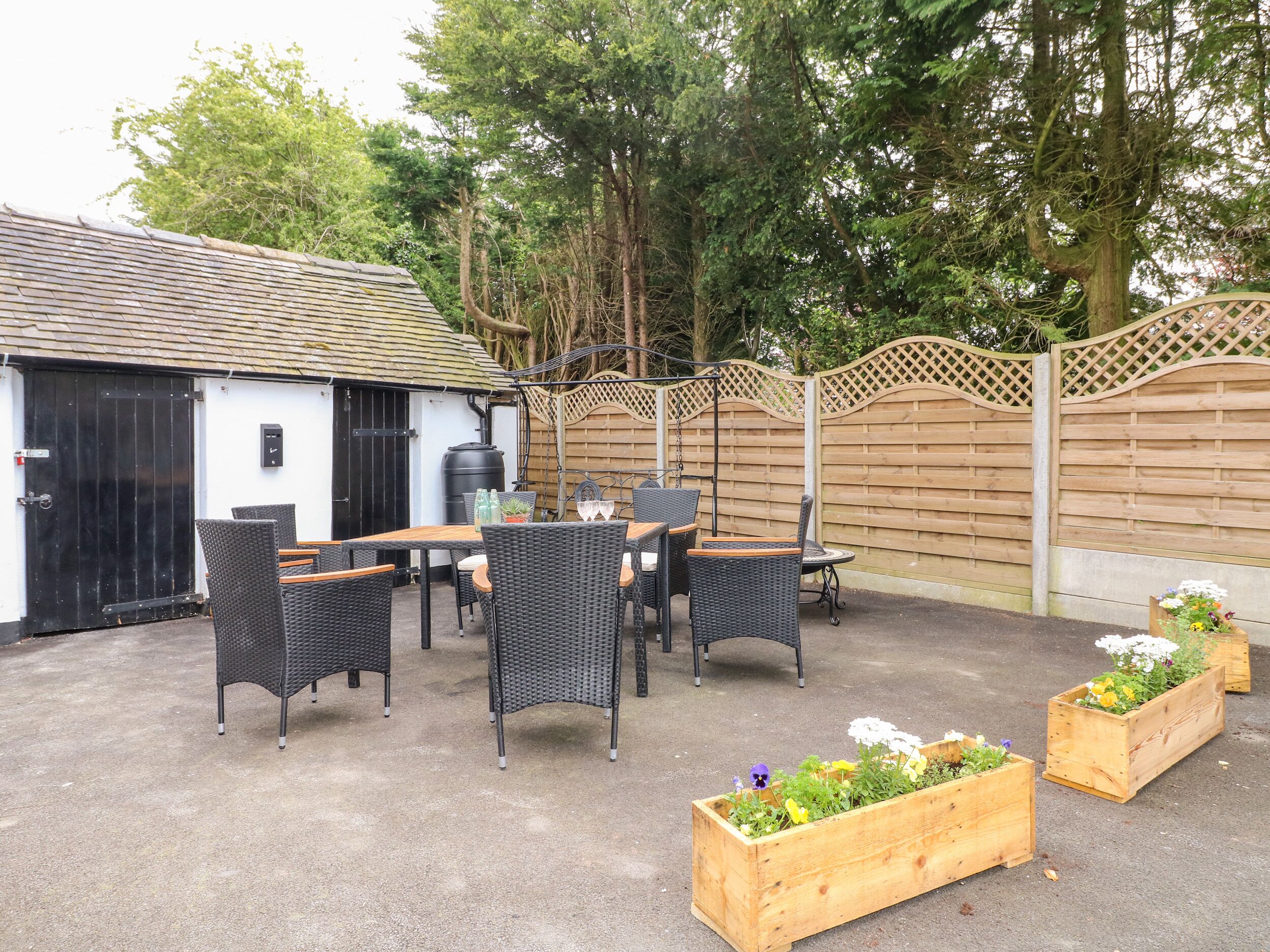 An outdoor patio with wicker furniture and a barbecue area.