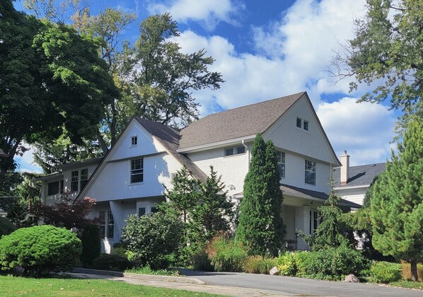 A two-story house with a gabled roof, surrounded by mature trees and well-maintained landscaping. - Historic Oak Park Residence (Oak Park)