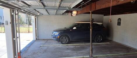 A parking garage with a blue SUV parked inside.