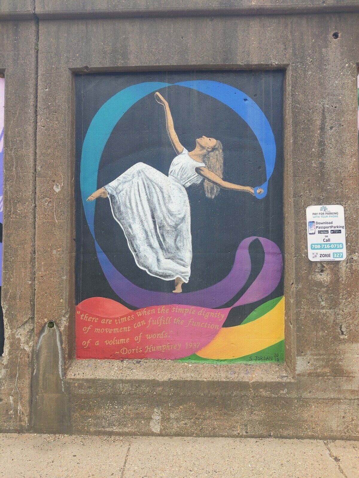 A mural of a woman in a white dress with a quote by Doris Humphrey.