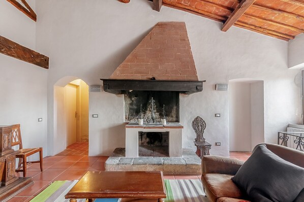 Un salon chaleureux avec une cheminée, des meubles en bois et un sol carrelé.