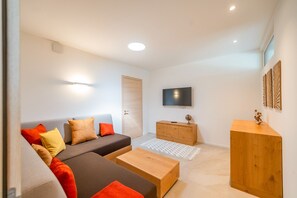A modern living room with a sofa, coffee table, wooden cabinet, and a flat-screen TV. - San Zeno - Three Bedroom Villa, Sleeps 8 (San Zeno di Montagna)