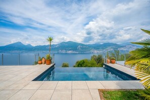 Ein Schwimmbad mit Blick auf einen See und Berge.
