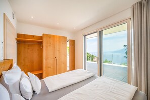 Ein Hotelzimmer mit Bett, einem Holzschrank und einem Balkon mit Aussicht.