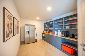 Eine moderne Küche mit einem Edelstahl-Kühlschrank, eingebauten Regalen und einer Kaffeemaschine.