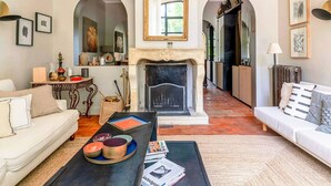 A living room with a fireplace, two sofas, a coffee table, and a dining table.