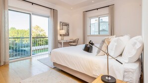 A bedroom with a large bed, a desk, a chair, and a view of the outdoors. - Villa Mingo - Five Bedroom Villa, Sleeps 10 (Almansil)