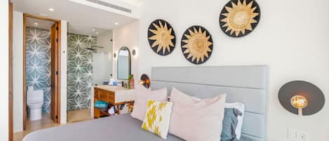Una habitación de hotel moderna con una cama grande, una mesita de noche, un espejo y decoración mural.