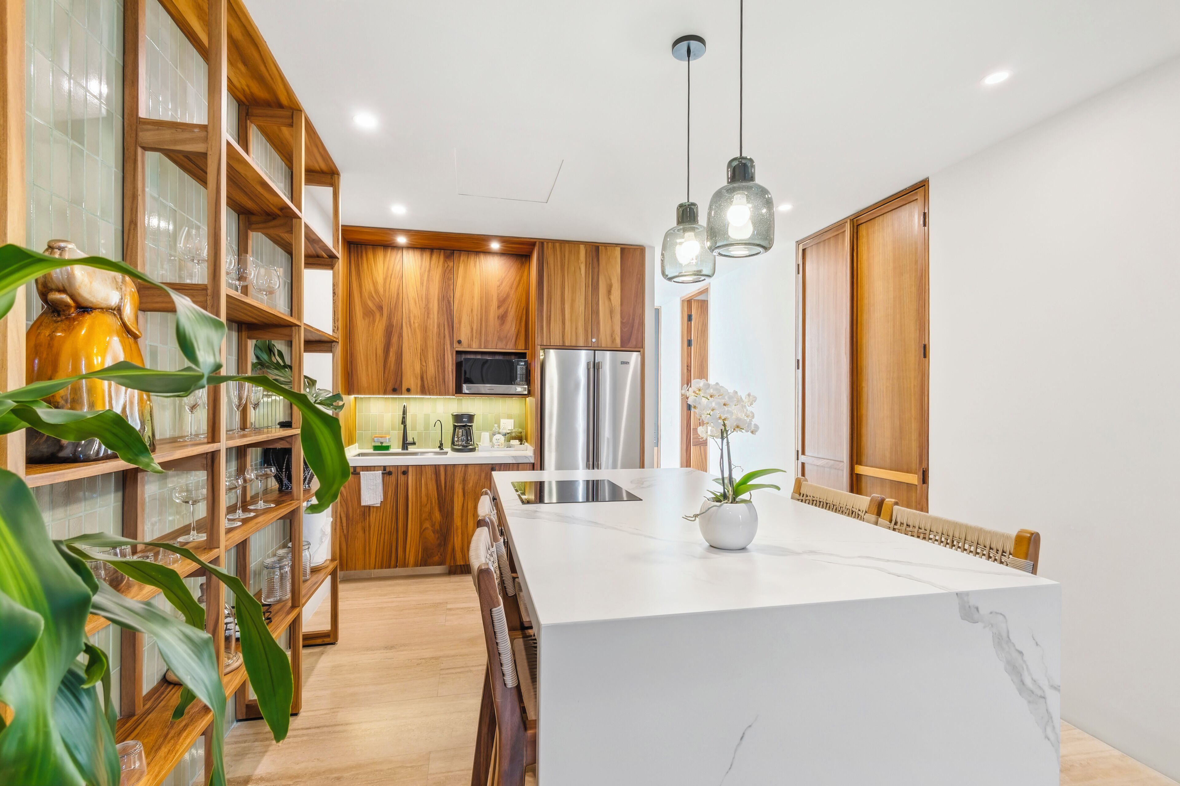 A modern kitchen with wooden cabinetry, a central island, and pendant lighting.