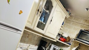 Una cocina con refrigerador, estufa, lavaplatos y gabinetes.