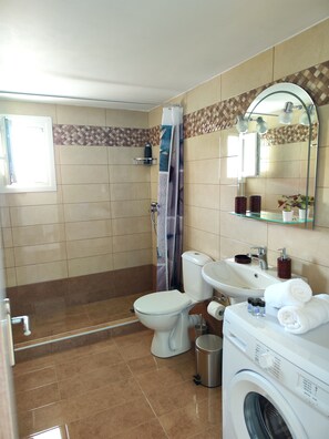 A bathroom with a toilet, sink, and washing machine.