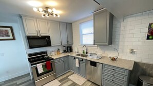 A modern kitchen with grey cabinets, stainless steel appliances, and a window providing natural light. - Relax with the whole family at this peaceful place to stay. (Columbus)