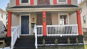 A two-story house with a front porch, a brick chimney, and a mailbox. - Relax with the whole family at this peaceful place to stay. (Columbus)