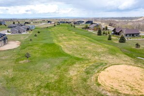 Stunning views of a well-maintained golf course surround this property, featuring a variety of houses with modern and traditional designs.