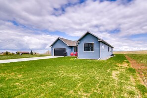 Stunning two-story home with a well-manicured lawn and a driveway leading to a garage.