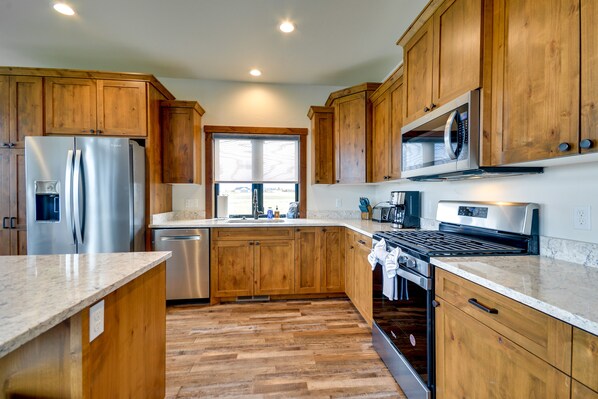 Enjoy cooking in this well-equipped kitchen with a refrigerator, dishwasher, microwave, and stove.