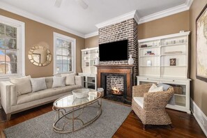 Relax by the fireplace in this inviting living room with comfortable seating and a TV.